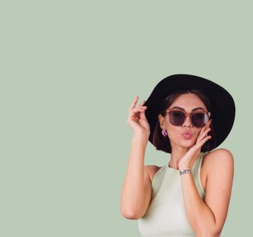 beautiful-stylish-woman-hat-sunglasses-posing-pink-red-wall-PhotoRoom